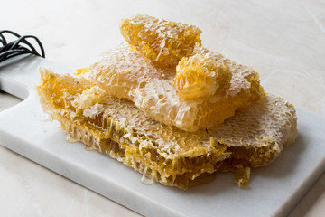 Fresh Honeycomb Slices with Honey on Marble Board.