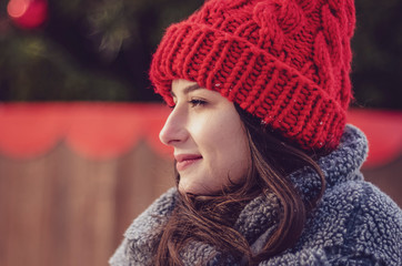 Outdoor portrait of elegant brunette woman wearing stylish red cap and warm coat. Space for text