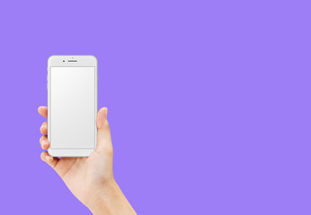 Hand holding white smartphone isolated on purple background