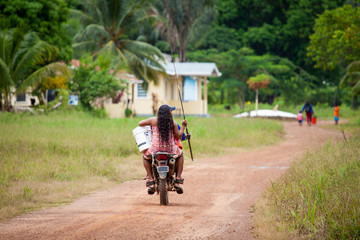 Frau und Mann auf einem Motorrad fahren zum Angeln mit der Angel in der Hand in Guyana, Südamerika