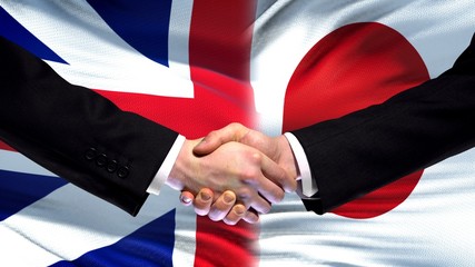 Great Britain and Japan handshake, international friendship, flag background