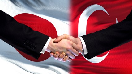 Japan and Turkey handshake, international friendship relations, flag background