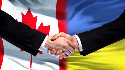 Canada and Ukraine handshake international friendship relations, flag background