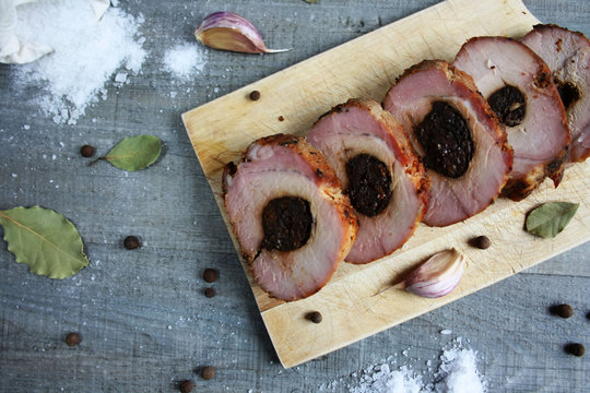 Pieczony schab ze śliwką pokrojony w plastry, wok&oacute;ł s&oacute;l i przyprawy