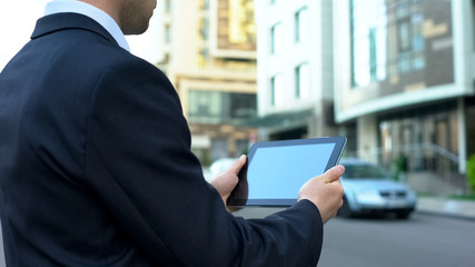 House buyer browsing housing offers on tablet, waiting for realtor, technologies