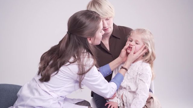 doctor is palpating lymph node on the neck of 5 years old girl, medical checkup