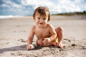 Fototapeta na wymiar Happy toddler playing on the beach on a sunny day
