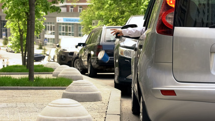 Driver throwing trash out of car window, contamination in city, dirty sidewalks