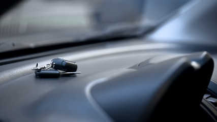 Obraz na płótnie Canvas Car keys on dashboard close up, driver leaving parked auto opened, car theft