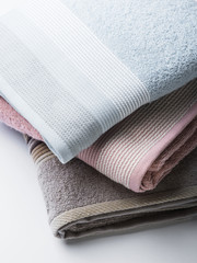 Pastel color clean folded towels on white