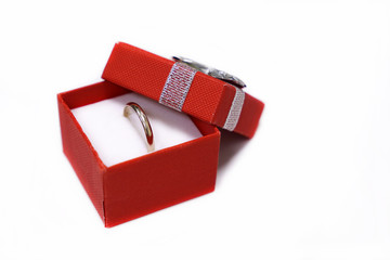 Red gift box with golden ring isolated on white background. Concept of marriage proposal, jewelry, Valentines gift, engagement, wedding ring, romantic present