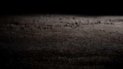 View of grey rough asphalt with little stones, street road at night, close up