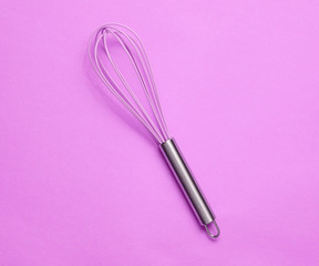 Kitchen corolla on purple background. Top view, cooking concept, minimalism.