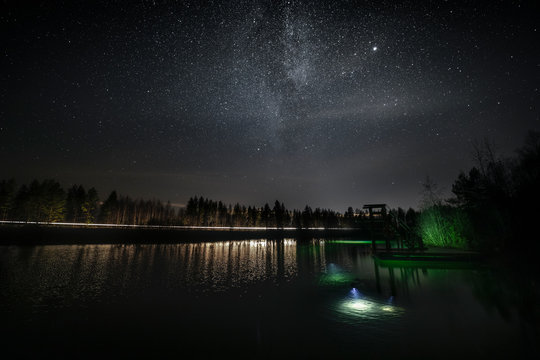 View of diving tower at lake against starry sky at night