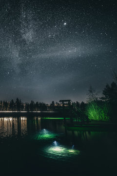 View of diving tower at lake against starry sky at night
