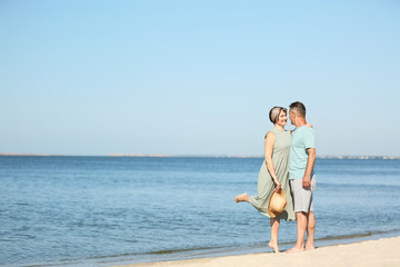 Fototapeta premium Happy mature couple dancing at beach on sunny day