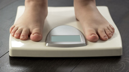 Female legs on scales closeup, weight loss program, measure dieting results