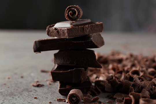 Curls and pieces of tasty chocolate on gray table