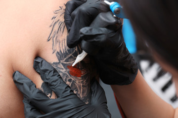 Fototapeta na wymiar Professional artist making tattoo in salon, closeup