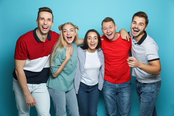 Group of friends laughing together against color background