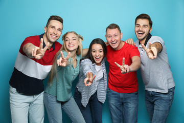 Group of friends laughing together against color background