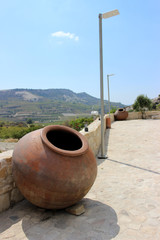 Amazing green bright landscape on the background of the mountains, with ancient clay barrels for the manufacture and storage of wine. Cyprus, Paphos