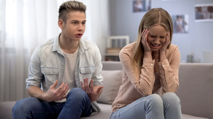 Obraz na płótnie Canvas Couple of teenagers quarrelling, male screaming, emotional girlfriend crying