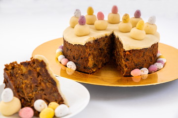 Easter Simnel Cake. Simnel cake with marzipan topping and eleven balls of marzipan representing the twelve apostles minus Judas. Mini chocolate Easter Eggs round the base. Focus on the cake.
