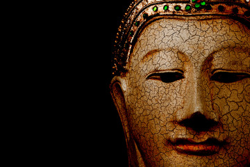 Statue of Buddha head with black space in background