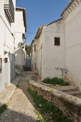 Fototapeta na wymiar White houses in stone alley, Granada, Spain