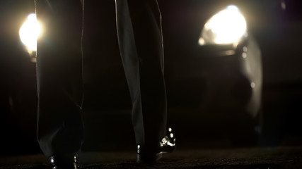 Man in business suit slowly walking to expensive car, shadow deals, collusion