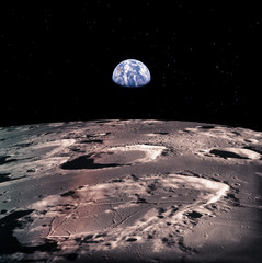 Earth rises above lunar horizon with huge meteor craters. Elements of this image furnished by NASA.