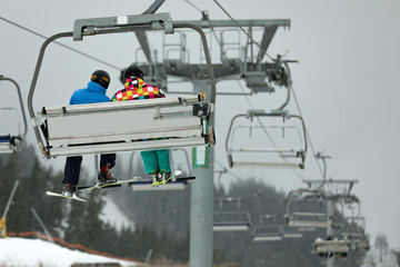 Chairlift with people at ski resort. Winter vacation