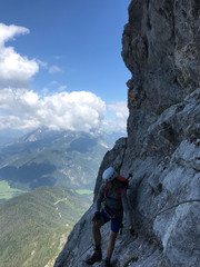 young man climbing high mountain landscape