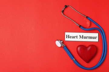 Flat lay composition with stethoscope and wooden heart on color background. Space for text