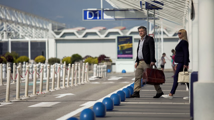 Man and woman standing near train station waiting for shuttle bus transportation