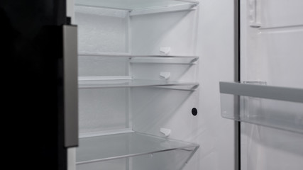 Opened empty refrigerator on exposition of kitchen appliances, fridge purchase