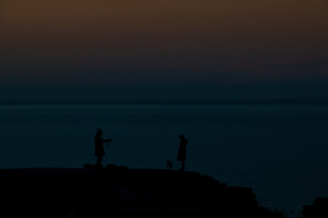Fototapeta na wymiar silhouette of a couple at sunset with the sea in the background