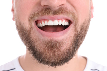 Obraz premium Young man with healthy teeth smiling on white background, closeup