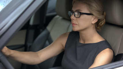 Serious business lady in car, driving to important meeting with partners, work