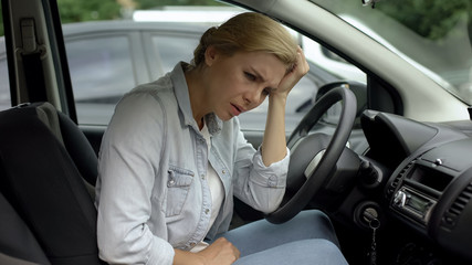 Depressed casual woman sitting in car, dissatisfied with her life, daily routine