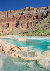 Aquamarine waters of the Little Colorado River flow towards its confluence with the Colorado River in Marble Canyon