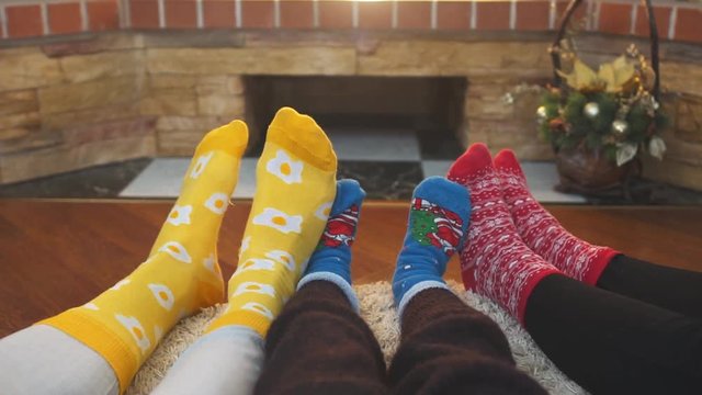 Feet in bright socks at home. Family with kid relaxing on the weekend together. Slow motion
