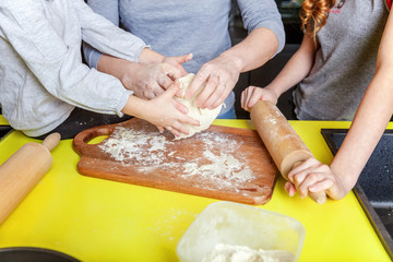 Happy family in kitchen. Mother and two children preparing dough, bake apple pie. Mom and daughters cooking healthy food at home and having fun. Household, teamwork helping, maternity concept