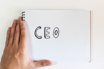 In the hands of a businessman a scrap of paper with the inscription:CEO