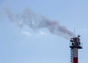 Smoke from industrial chimneys against the blue sky. Pollution.