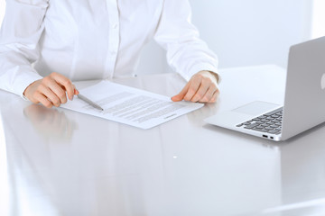 Close-up of female hands with pen over document,  business concept. Lawyer or business woman at work in office