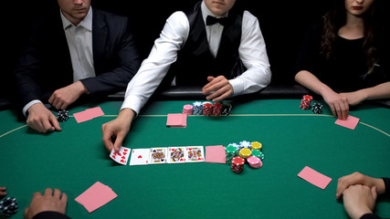 Poker dealer turning up cards at green casino table, hobby tournament, luck