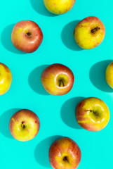 Apples with hard shadow on aqua background, flat lay image.