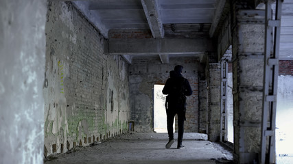 Teenage guy walking in dangerous place, abandoned house, risk of kidnapping